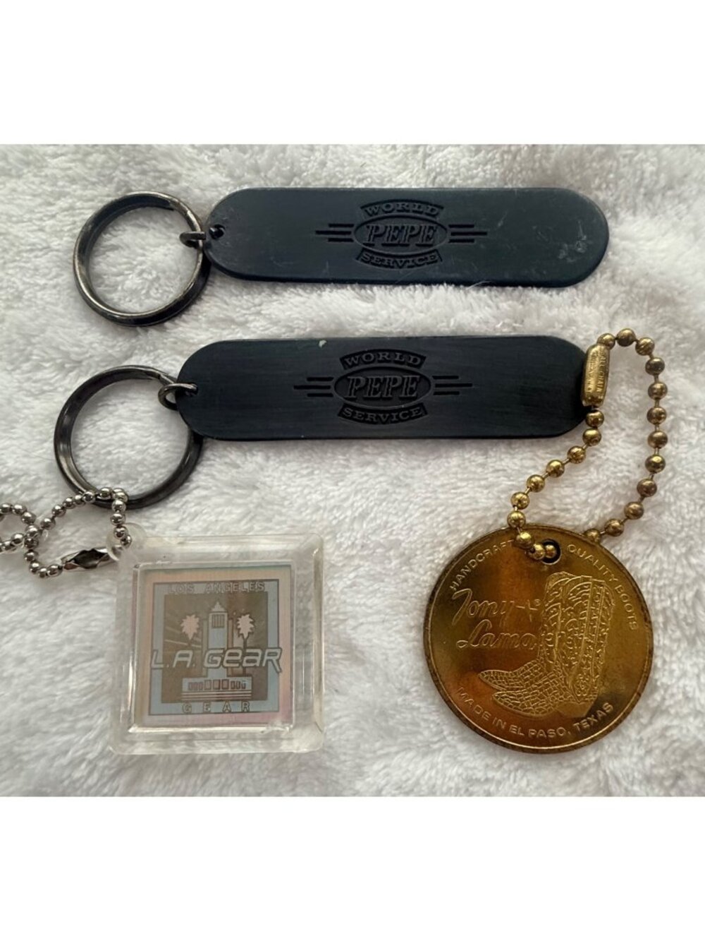 Vintage Keychain Lot Featuring Tony Lama, Pepe World Service & LA Gear Collectib